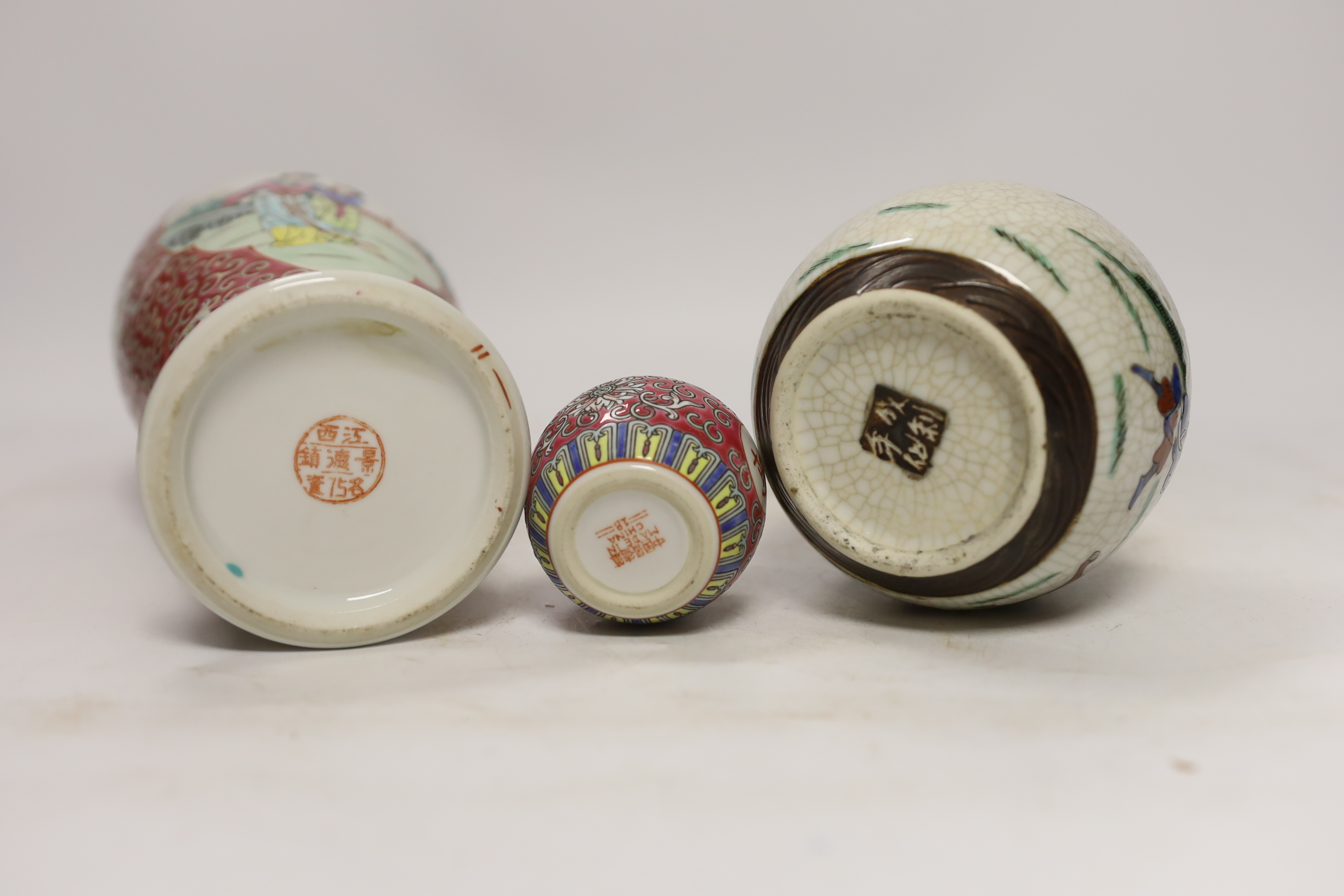An early 20th century Chinese famille rose vase and cover, a similar small jar and cover and a famille verte crackleglaze jar and cover, tallest 31cm. Condition - jars good, vase poor